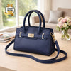 Navy blue handbag with gold accents on a table in a living room setting.