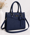 Navy blue handbag with a bow detail on a white background