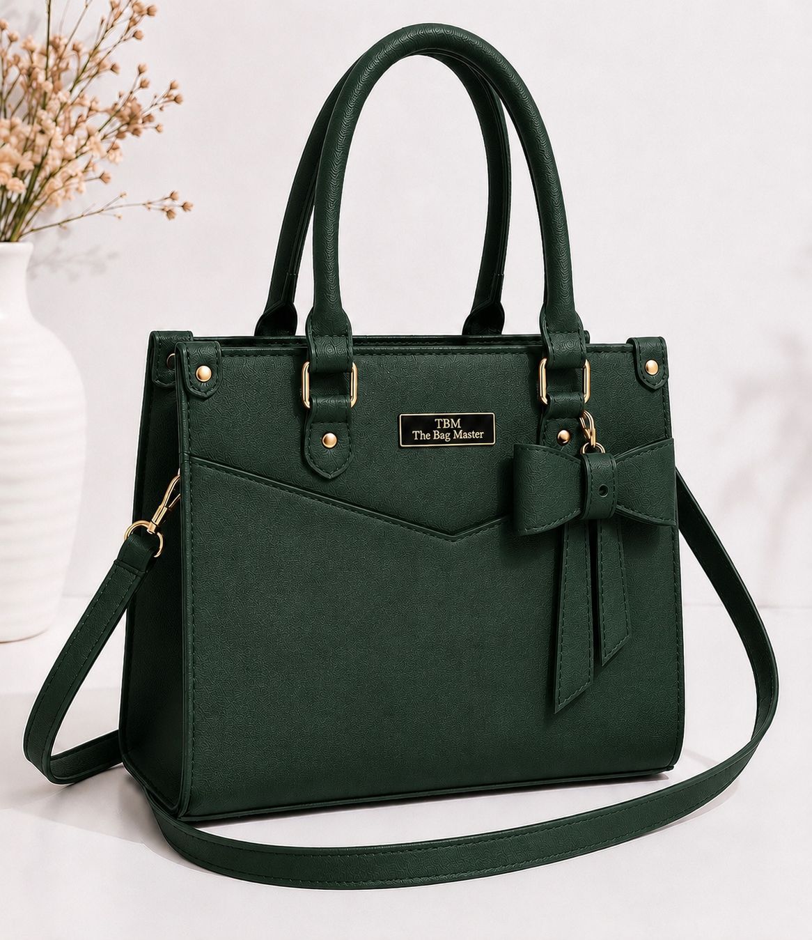 Green handbag with a bow detail on a white background