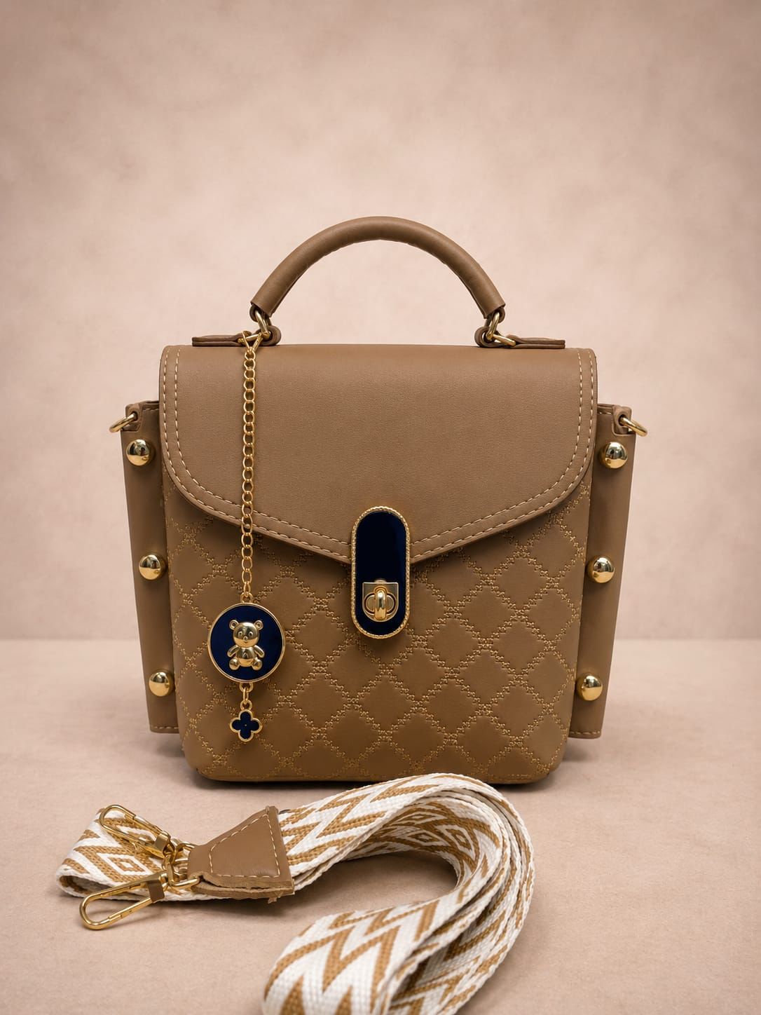 Brown handbag with decorative elements on a beige background