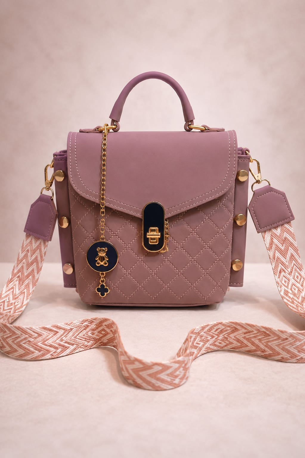 Pink handbag with a decorative strap on a light background