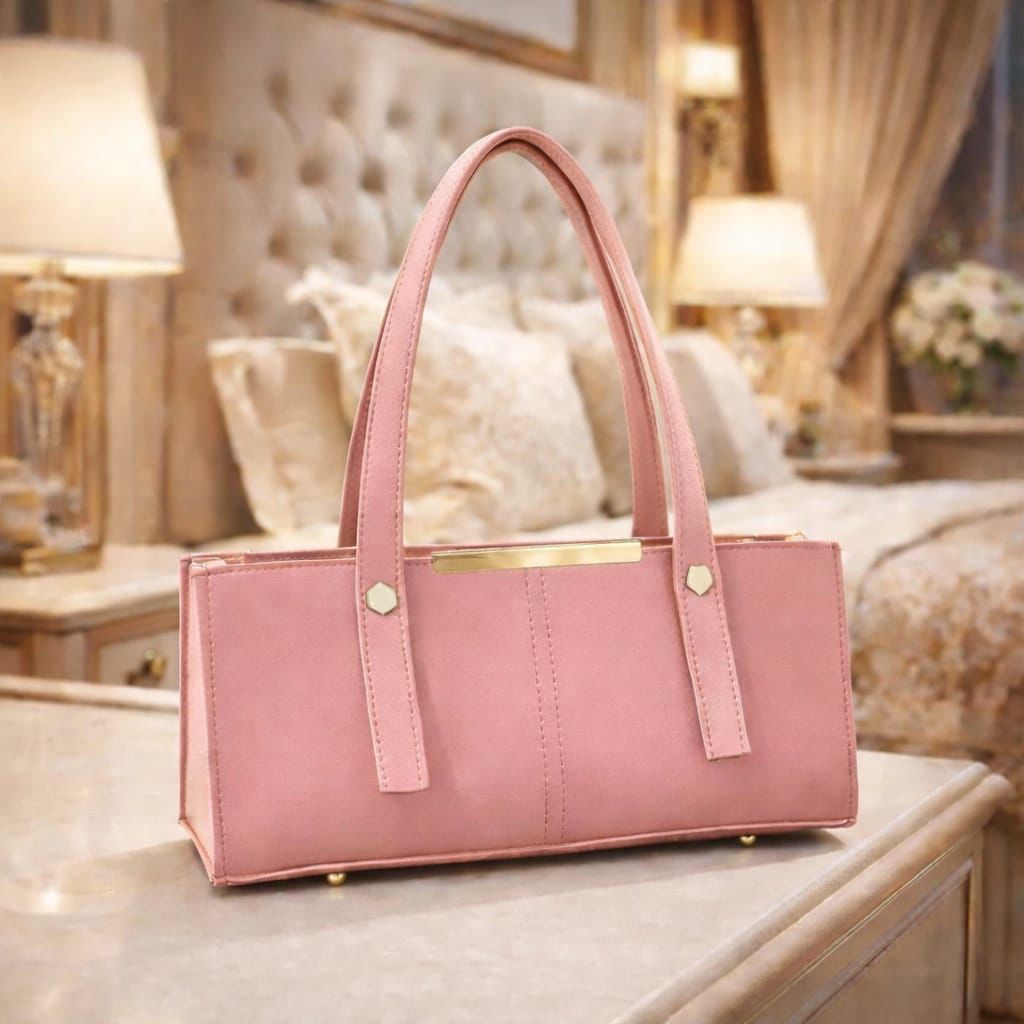 Pink handbag on a surface with a blurred background of a room.