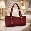 Maroon handbag on a table with a blurred background