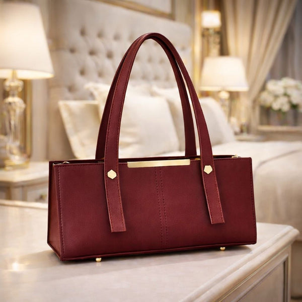 Maroon handbag on a table with a blurred background
